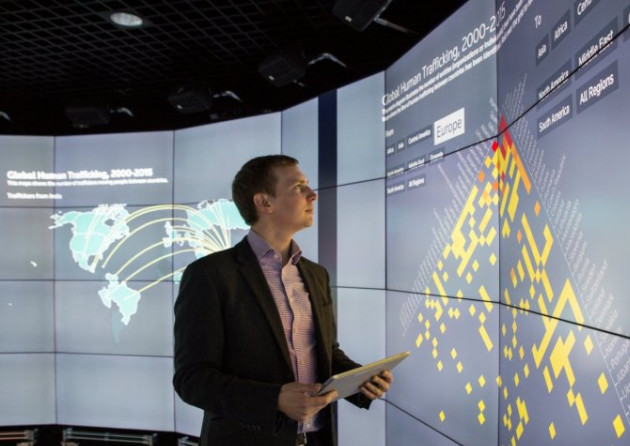 A man standing in the data science centre looking at a large screen