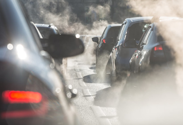 Cars in a traffic jam with pollutive smoke emitting from their exhaust fumes